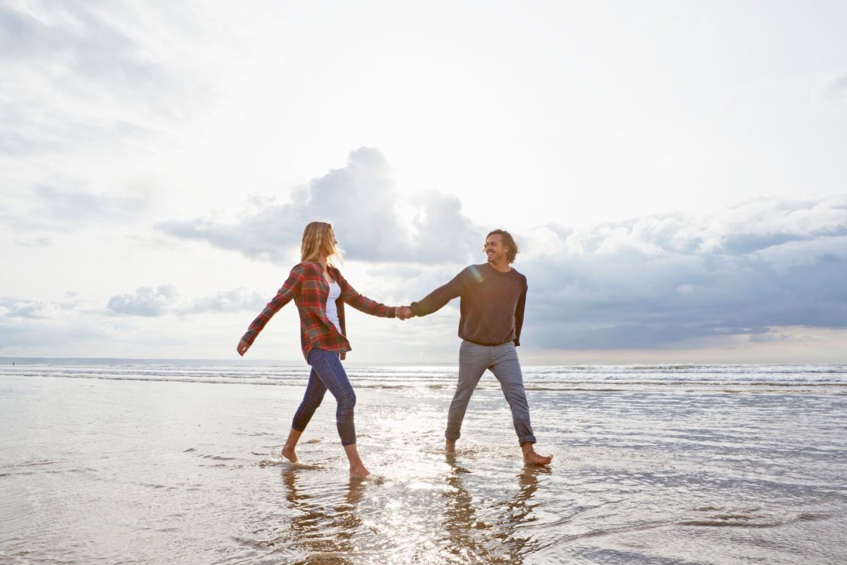 a couple walking on the beach in the winter